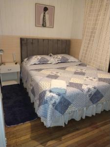 a bed with a quilt on it in a bedroom at Guillermo Marconi in Los Ángeles +2 photos