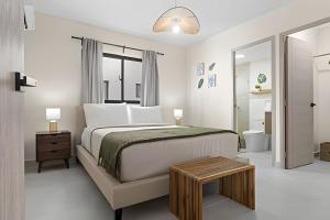 a white bedroom with a bed and a bathroom at Atabey II – Epic Residence, Bávaro in Punta Cana +21 photos