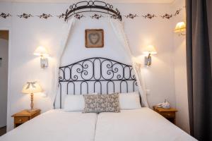 a bedroom with a white bed with a black headboard at The Originals Boutique, Hôtel La Ferme du Pape, Eguisheim in Eguisheim
