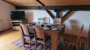 a dining room with a table and chairs and a television at Ferienwohnung Jochen Riederer in Neualbenreuth