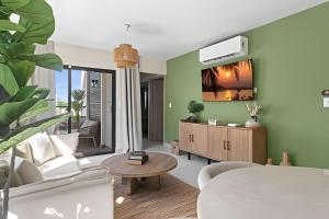 a living room with a couch and a tv on the wall at Atabey II – Epic Residence, Bávaro in Punta Cana