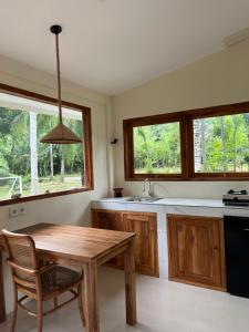 a kitchen with a wooden table and a sink at Kapal Dream Homestay in Selong Belanak