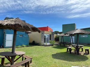two picnic tables and umbrellas in a yard at Ayres de Cobo in Mar de Cobo