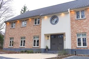 a brick house with a black door at Bed and Breakfast L'Orée Du Bois in Wavre