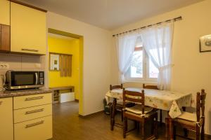 a kitchen with a table with chairs and a microwave at Apartment Marta in Ražanac