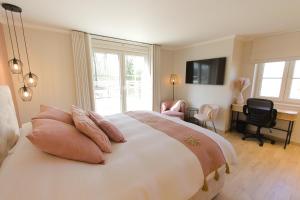 a bedroom with a large bed with pink pillows at Bed and Breakfast L'Orée Du Bois in Wavre +45 photos