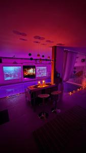 a purple room with a table and some chairs at Catalpa in Al Ḩārah +3 photos