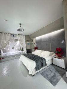 a bedroom with a large bed and a large window at Catalpa in Al Ḩārah