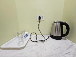 a coffee maker and a tea kettle on a counter at V3 Inn Private Limited in kolkata