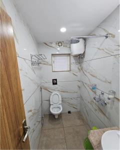 a white bathroom with a toilet and a sink at V3 Inn Private Limited in kolkata +1 photo