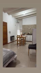 a room with a bed and a table and a kitchen at Monoambiente centrico-Paseo Plaza in Navarro