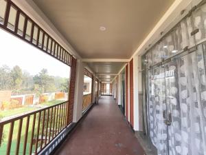 an empty corridor of a building with windows at Ankush Resort in Vishnupur