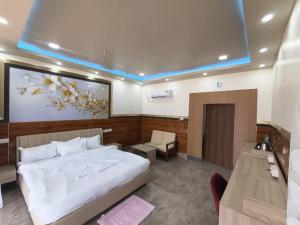 a bedroom with a large white bed and a television at Ankush Resort in Vishnupur