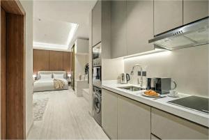 a kitchen with a sink and a bed in a room at LIV by Yamama - KAFD in Riyadh