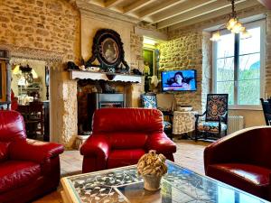 a living room with red chairs and a table at Aux Caprices des Dieux in Marnes