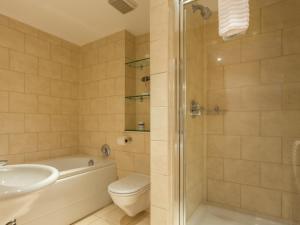 a bathroom with a tub and a toilet and a sink at Reflections - Balcony Views of Poole Harbour in Poole