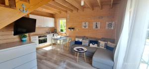 a living room with a couch and a kitchen at Plażowisko in Dębki