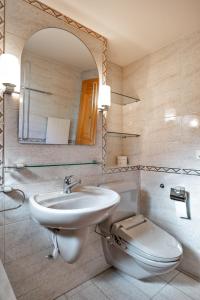 a bathroom with a sink and a toilet and a mirror at Chesa Foulla Rosa - Celerina in Celerina +40 photos
