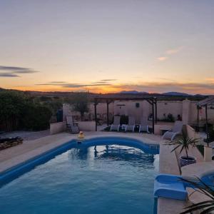 a swimming pool with a sunset in the background at Bed Breakfast - Casa Rural in Úbeda