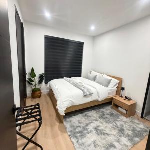 a bedroom with a bed with a black headboard at Downtown Luxe Stay - High River in High River