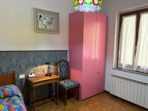 a pink cabinet in a bedroom with a table and a chair at Casa Adriana in Pradalunga +11 photos