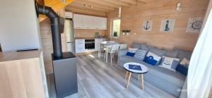 a kitchen and a living room with a couch and a stove at Plażowisko in Dębki