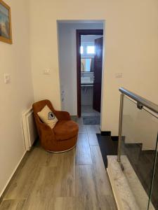 a living room with a chair with a pillow on it at Dar Zina in Mteurch