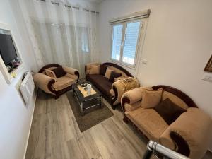 a living room with two couches and a table at Dar Zina in Mteurch