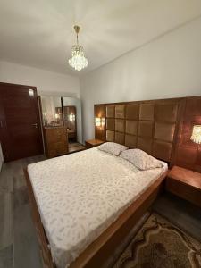 a bedroom with a large bed and a chandelier at Dar Zina in Mteurch