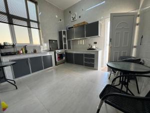 a large kitchen with a table and a table and chairs at January Rest in Sur
