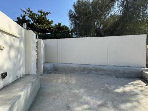 a white fence in front of a yard at January Rest in Sur
