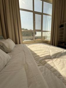 a large white bed in a room with a window at January Rest in Sur +15 photos