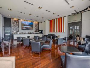 a restaurant with tables and chairs and a bar at Sofitel La Reserva Cardales in Río Luján