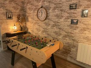 a foosball table with a clock on a brick wall at Linstant tranquille in Romorantin