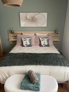 a bedroom with a large bed with two pillows at Linstant tranquille in Romorantin