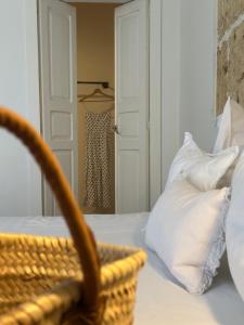 a bedroom with a basket on a bed with pillows at F Home in Noto