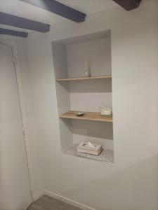 a room with a white wall with shelves on the wall at Linstant tranquille in Romorantin +11 photos