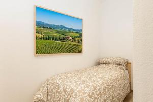 a bedroom with a bed with a picture on the wall at House Tuscany in Poggibonsi