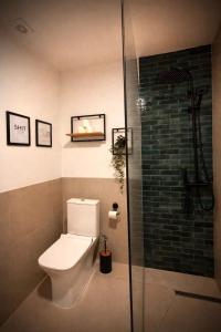 a bathroom with a toilet and a glass shower at Stylish Townhouse- central & quiet in Prishtinë