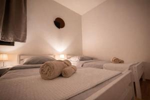 two beds with towels on them in a bedroom at Stylish Townhouse- central & quiet in Prishtinë