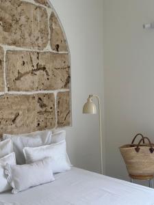 a bedroom with a stone wall and a bed at F Home in Noto
