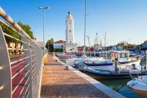 a lighthouse in a marina with boats in the water at Hotel Biancamano in Rimini