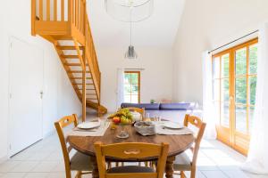 a dining room with a table and chairs and a staircase at Les Chambres du Méteil in Mazé
