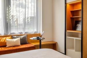 a bedroom with a bed and a table with a laptop at FirstName Bordeaux, Part of JdV by Hyatt in Bordeaux