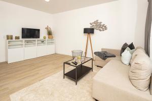 a living room with a couch and a tv at Ostsee Suite 3 - Strandperle in Niendorf