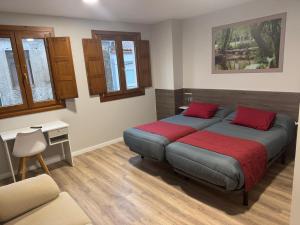 a bedroom with a bed with red pillows on it at Pension San Anton in Melide +48 photos