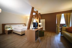 ein Schlafzimmer mit Bett, Fernseher und Sofa in der Unterkunft Hotel Pangrazzi - 3 stelle superior in Fucine + 35 Fotos