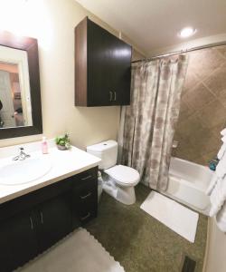 a bathroom with a sink and a toilet and a shower at Old Fort Loft King & Queen suites nearest accomodation to Marshals Museum power your EV for free! in Fort Smith +25 photos