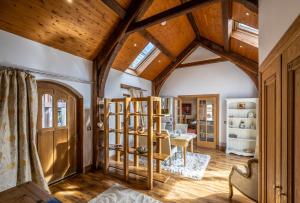 a living room with wooden ceilings and a room with a table at The Hideaway in Banchory