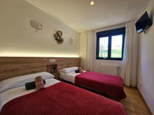 a hotel room with two beds and a window at PENSION ROSELLA in O Pedrouzo +34 photos